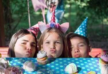 three girls with birthday hats on a table