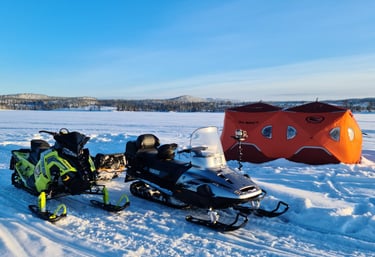 Snowmobiles and two ice fishing tents.