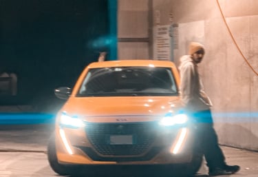Ragazzo accanto a Peugeot 208 accesa. Passione per le auto raccontata in un blog autentico