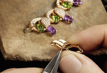 Setting faceted cut amethysts stones into a large 18 karat yellow gold linked necklace.