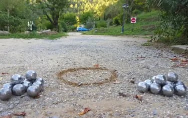 deux amas de boules de pétanques sur un terrain de pétanque