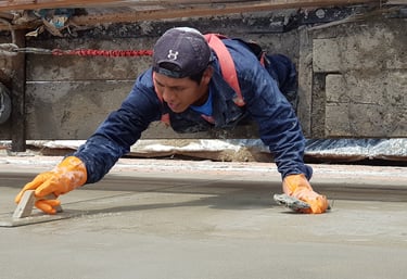 Operario fratachando revoque en altura con balancín