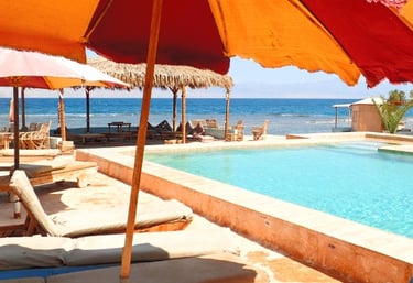 une piscine sur la plage avec parasols et chaises longues 