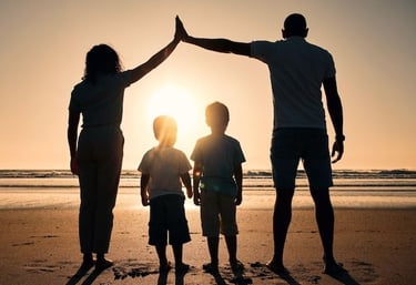 uma família de três pessoas em pé na praia