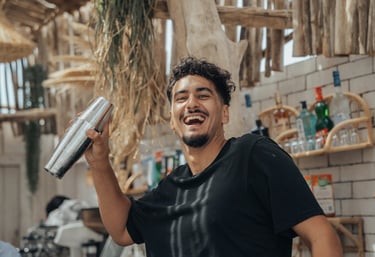 Barman en pleine préparation d’un cocktail signature au bar de Playa Amor