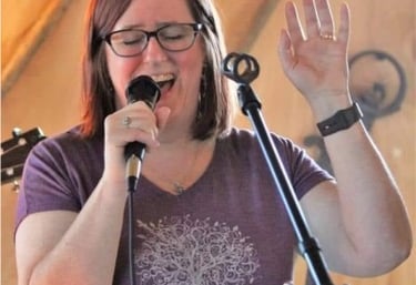 Speech Pathologist, Joy Walsh, singing into a microphone