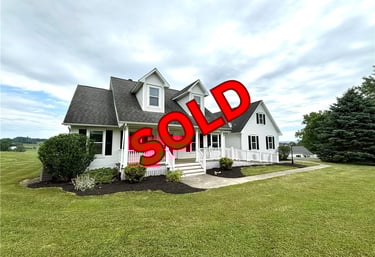 a sold sign for a home in a residential neighborhood