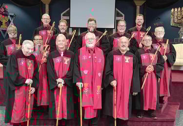 a group of men in red robes standing in front of a stage
