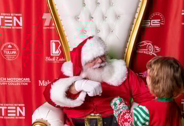 The Santa Cowboy gets a fist bump from a Make A Wish participant