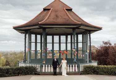 Bride and groom holding hands standing infront of band stand