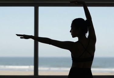 Close up of a practitioner's silhouette against a large window in a North American coastal setting. Elegant posture, calm morning light, light blue-grey tones.