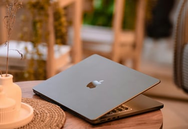 a laptop computer sitting on a table with a candle and a candlelight