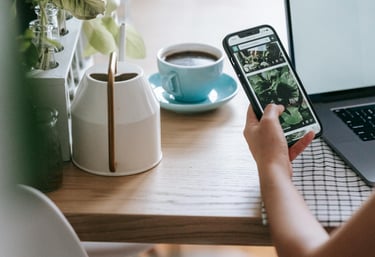 a person sitting at a table with a laptop and a cell phone