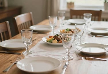 A close-up of a neatly set dining table in a bright North American / US communal dining room, representing shared meals and community warmth.