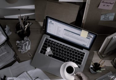 Mesa de trabajo con portátil, papeles y material de oficina, imagen para la sección quiénes somos