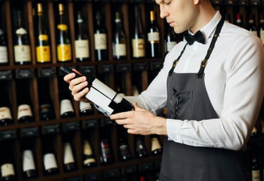 A person reviewing a wine bottle in the cellar