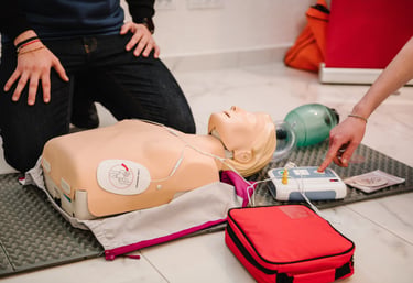 Close up image of CPR mannequin with an AED trainer next to it