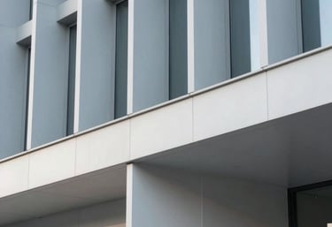A minimalist, artistic shot of a modern architectural detail in a Western European tech hub, showcasing structural precision and professional elegance in light blue-grey and off-white.
