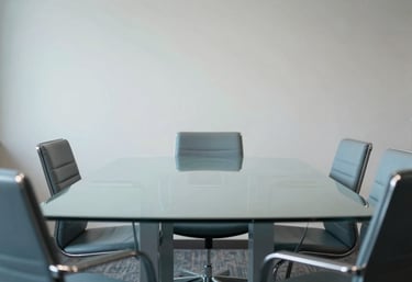 A minimalist meeting room in a North American / US agency, featuring a glass table and chairs with subtle Pale Sky Blue light reflections.