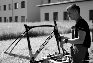Karl Guillois officiant comme mécanicien sur un cadre de route du peloton professionnel World Tour