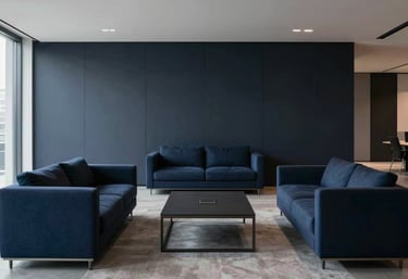 A wide, cinematic shot of a modern, minimalist office lounge with clean lines and premium furniture. The color palette is dominated by deep midnight navy and dark steel blue.