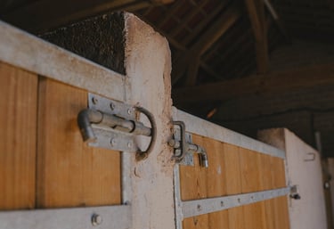 Close-up a wooden horse stable door inside a barn.