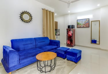 "Living room of 1 BHK apartment with sofa and TV" "Dining area inside 1 BHK apartment"