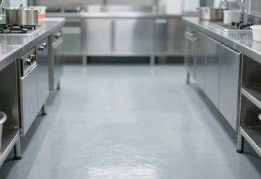 A sparkling clean commercial kitchen floor and baseboards, reflecting a sterile and pest-free environment under bright lights.