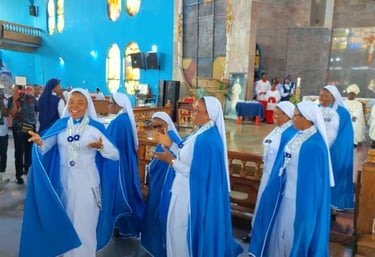 Smiling Catholic nuns in blue and white habits singing during a church service at a cathedral.
