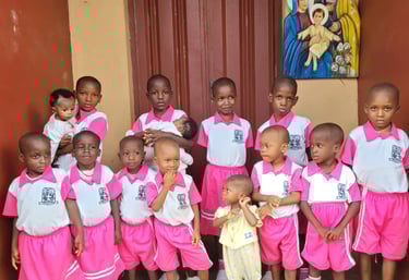Group of African students in pink and white uniforms posing for a school photo together.