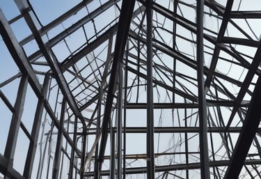 A sleek steel framework of a modern building under construction against a clear sky.
