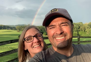 husband and wife taking a selfie on our lavender farm with rainbow - colored rainbows