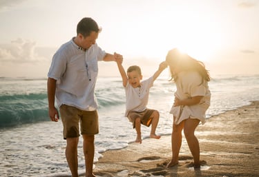 Father lifting child during sunset family session at Melasti Beach Bali, candid emotional moment