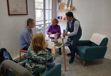 Olivier Paris debout devant trois personnes assises autour d'une table