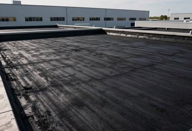 Finished black modified bitumen flat roof on a modern North American / US industrial building, high-contrast lighting, clean edges.