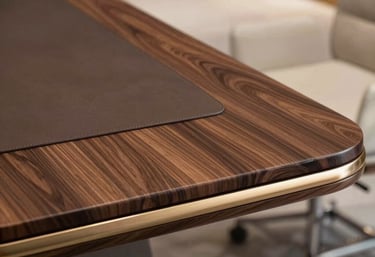 A softly lit close-up of rich walnut wood grain meeting matte black metal in a sleek executive desk corner.
