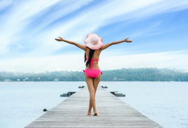 a woman in a pink bikinisuit standing on a dock