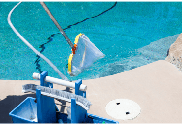 Image of a pool being skimmed and cleaned free of leaves and debris and vaccuumed.