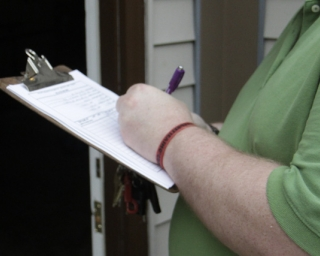 Man holding clipboard symbolizing real-time digital reports during home checks.