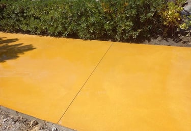 Hormigón pulido color amarillo para camino exterior.