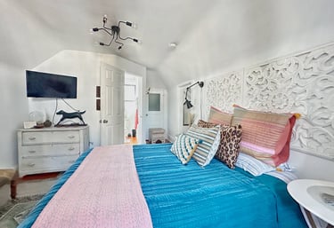 a bedroom with a bed and a television