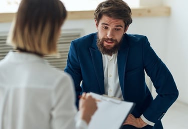 a man and woman in business attire sitting in a meeting room