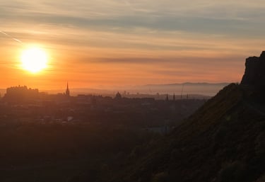 A golden sunset over the Edinburgh city skyline and historic Edinburgh Castle from Salisbury Crags.