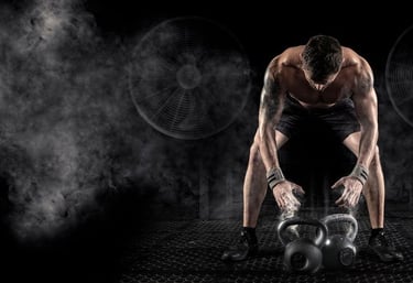 Homem musculoso em academia escura curvado sobre kettlebells com pó de magnésio pronto pro treino