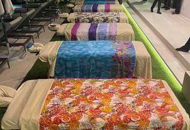 a row of massage beds with colorful bedspreads for a group