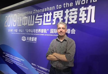 a man standing in front of a sign that says,'welcome to the world