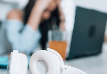 Mulher no trabalho, com as mão no rosto por conta da Ansiedade e preocupação no trabalho