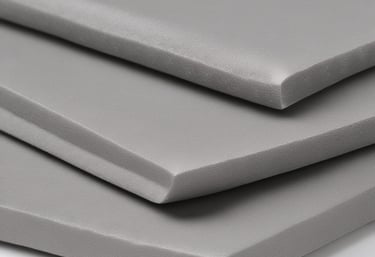 A white, irregularly shaped block of polystyrene foam is positioned centrally against a plain, light background. The texture of the foam is visible, showcasing its porous and slightly rugged surface.