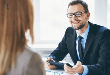 a tcrutr employee of payroll team in a suit and tie is smiling at the client