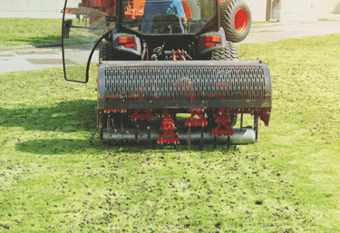 Professional lawn aeration service relieving compacted soil for healthier grass growth